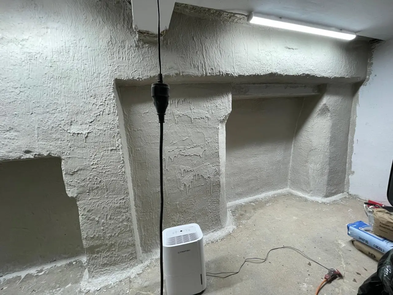 Fertig sanierte Garagenwand mit weißer TOBOLIN Sanierfarbe