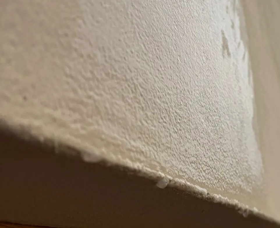 Kondenswasser läuft als feiner Wasserfilm an einer kalten Innenwand herunter